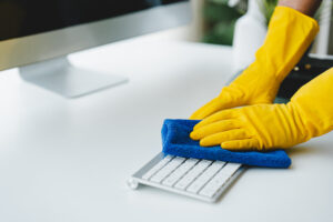 commercial cleaning company in contra costa county cleaning office desk keyboard with yellow gloves