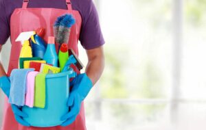 commercial cleaner holding a bucket of cleaning products