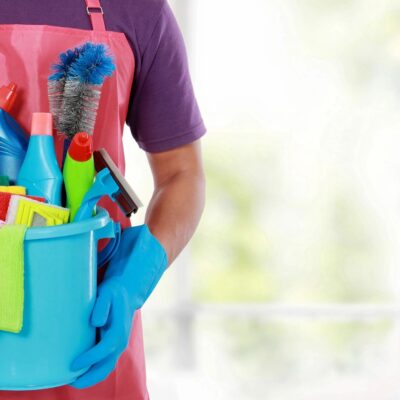 commercial cleaner holding a bucket of cleaning products