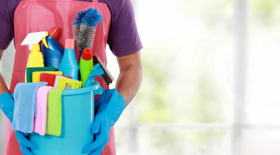 commercial cleaner holding a bucket of cleaning products