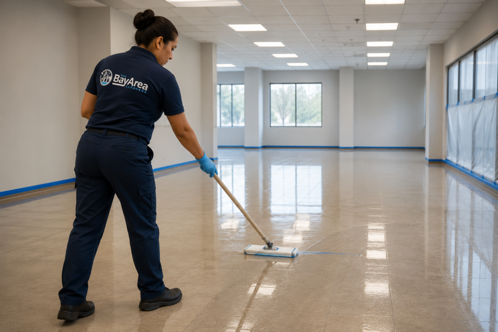 How to Strip and Wax Floors: Process, Cost and When to Skip It 1 Bay Area Cleaners technician applying commercial floor finish with a microfiber mop in an empty office space.